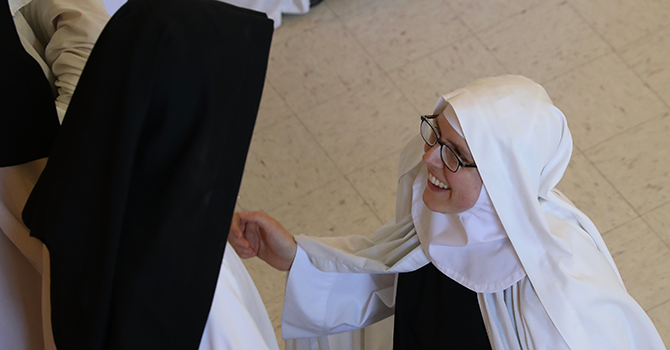 Before reciting her vows, Sister Joanna kneels before Sister Anne Marie, superior of Valley of Our Lady Monastery.