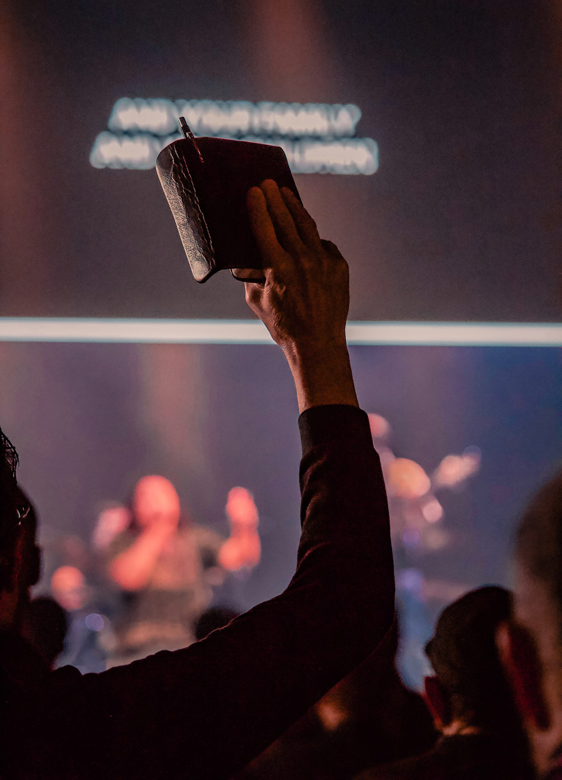 Photo of someone holding up bible in crowd